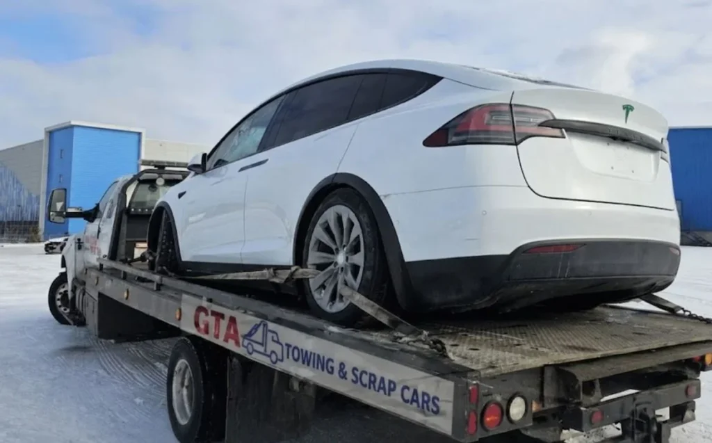 Professional junk car removal service in the GTA: A damaged vehicle being towed for scrap by GTA Towing & Scrap Cars