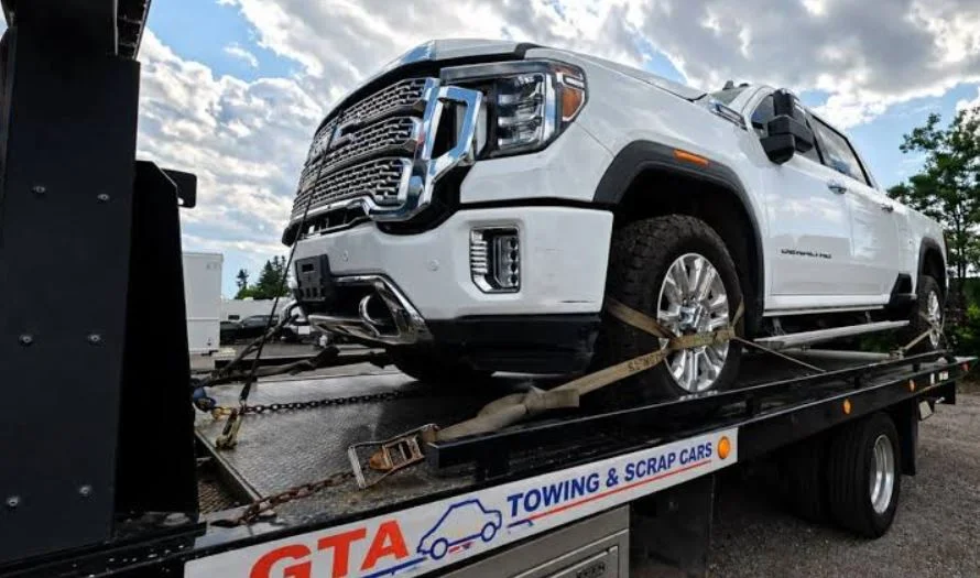 Professional flatbed tow truck performing scrap car removal Toronto service for an end-of-life vehicle.
